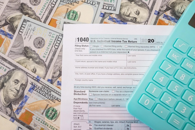 Premium Photo | Tax form 1040 with a calculator on a money background ...