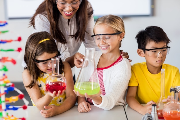 Premium Photo | Teacher helping pupils doing science