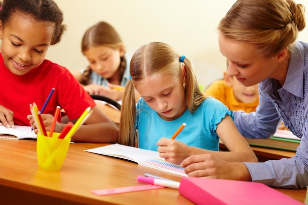 Teacher helping students with written work