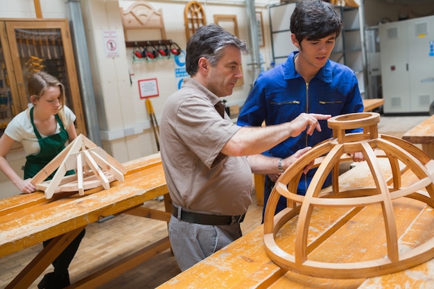 Premium Photo | Teacher helping a student in a woodwork class