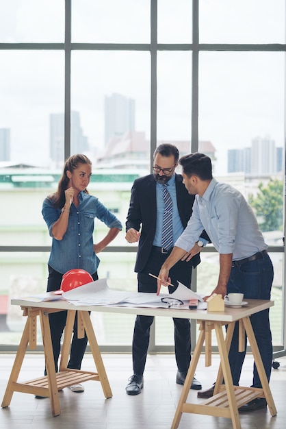 Premium Photo Team Of Multiethnic Architects Working On Construction Plans In Meeting Room