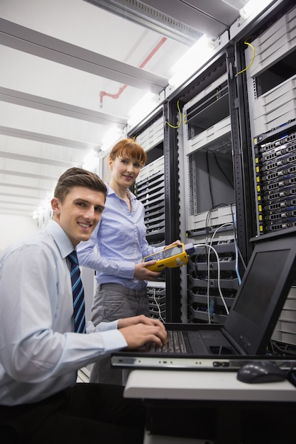 Premium Photo | Team of technicians using digital cable analyser on servers