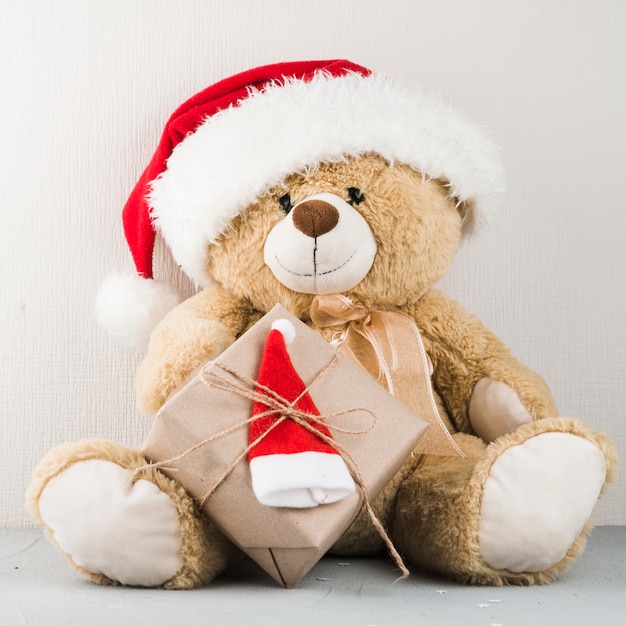 Teddy bear in santa hat with gift | Free Photo