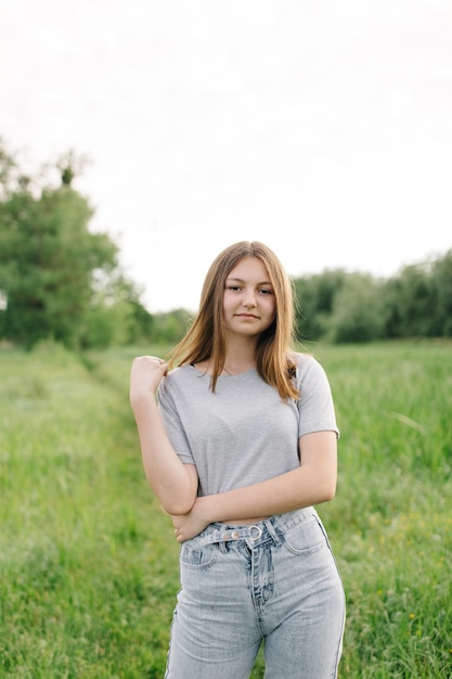 Premium Photo | Teen girl in gray tshirts and gray jeans on the green ...