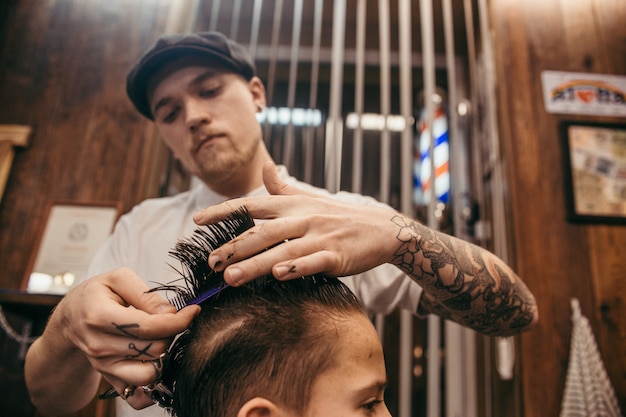 Premium Photo Teenage Boy Haircuts Hairdresser In The Barber Shop Fashionable Stylish Retro Hairstyle Portrait Of A Child With A Beautiful Haircut