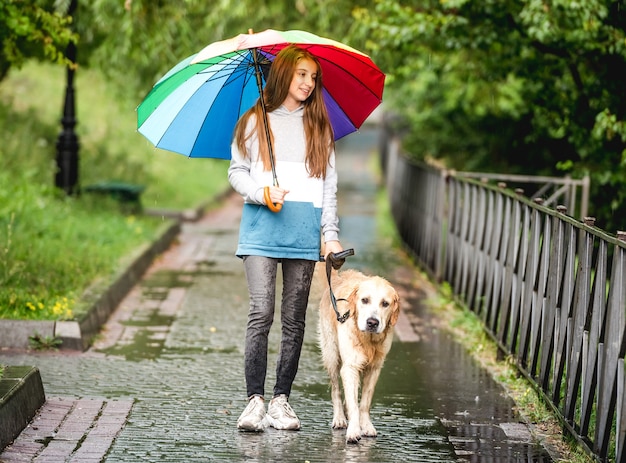 Premium Photo | Teenage girl walking with golden retriever dog at rainy day