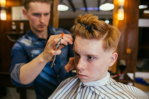 Teenage Redhead Boy Haircuts Hairdresser In The Barber Shop