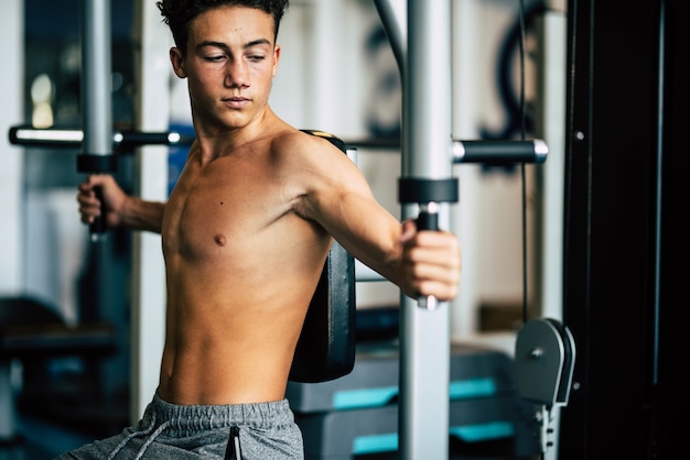 Premium Photo | Teenager alone at the gym doing exercises and looking ...