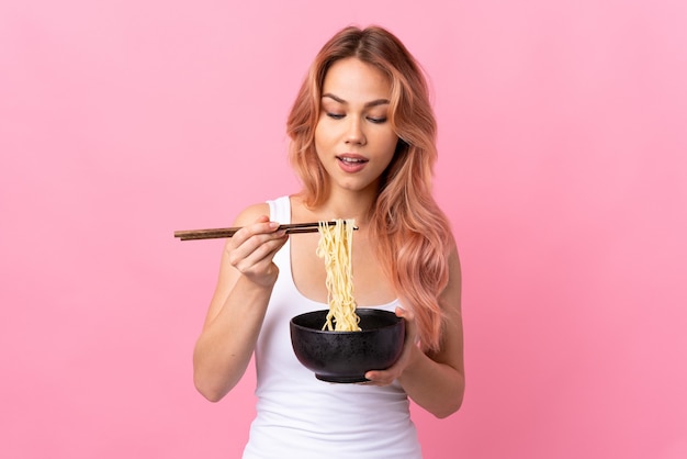 Premium Photo | Teenager girl over isolated pink holding a bowl of ...