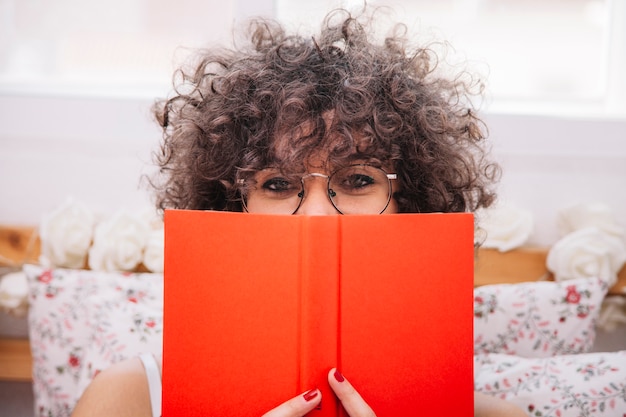 Teenager hiding face behind book | Free Photo