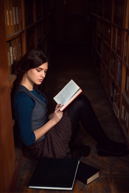 Premium Photo | Teenager sitting on a floor of library and read.