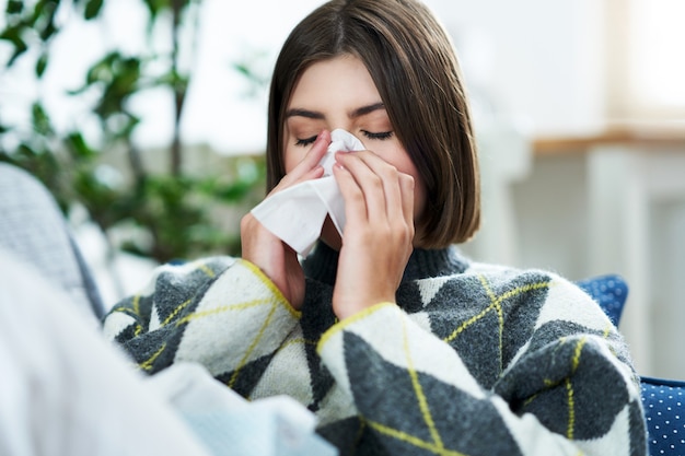 Premium Photo | A teenager sneezing in a tissue in the living room