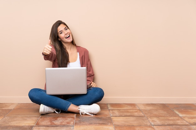 Teenager Student Girl Sitting On The Floor With A Laptop With