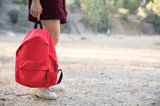 Teenager waiting with backpack in hand in park Free Photo