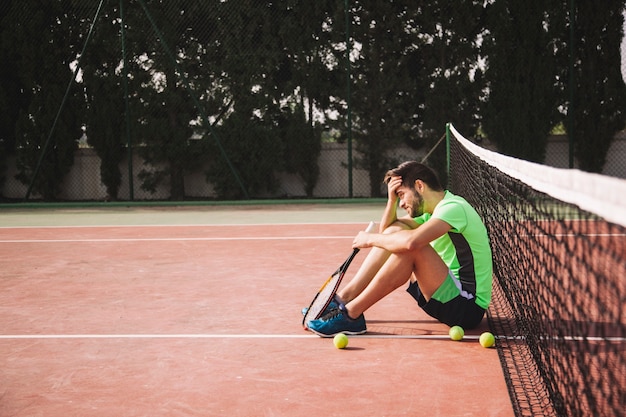 Free Photo | Tennis player leaning against net in frustration