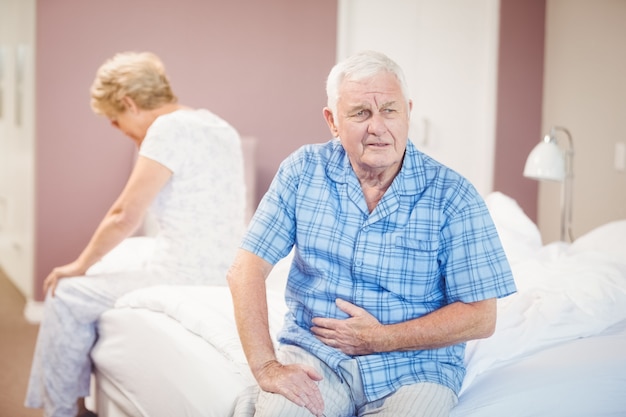 Tensed senior man and woman sitting on bed Premium Photo