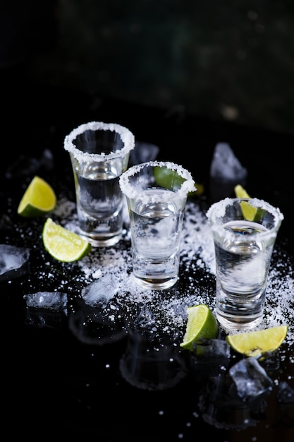 Premium Photo | Tequila shot with lime and salt on black background