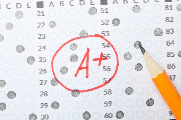Test score sheet with answers, grade a+ and pencil, close up Premium Photo