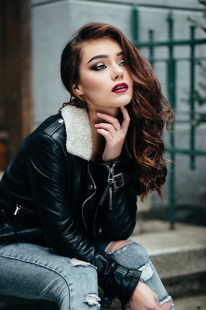 The beautiful girl sits on the stairs Free Photo