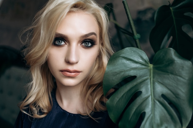 The elegant girl stands near plants Free Photo