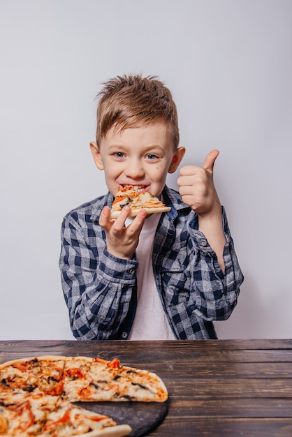 大きな喜びを持つ男はピザを食べて白い背景のように見せます プレミアム写真
