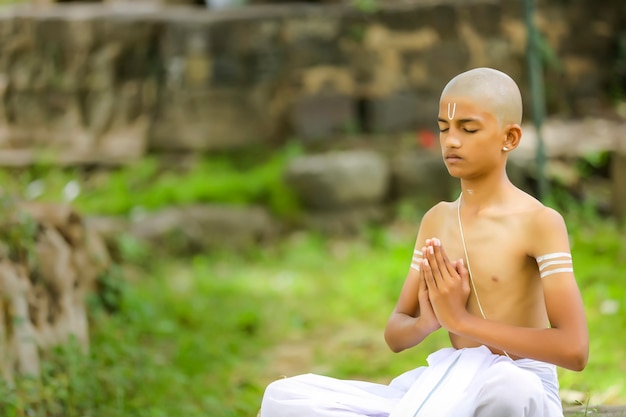 瞑想をしているインドの僧侶の子供 プレミアム写真