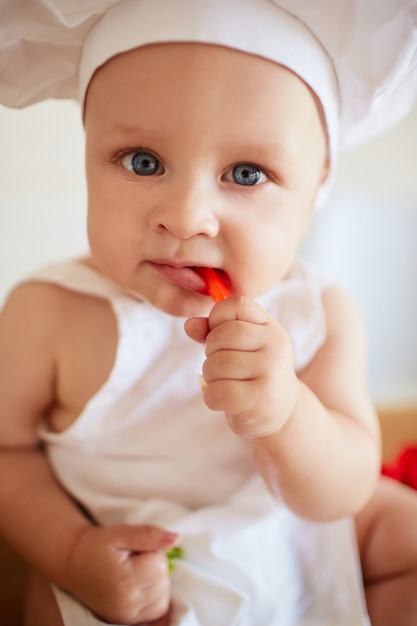 かわいい赤ちゃんが赤い紙を食べる 無料の写真