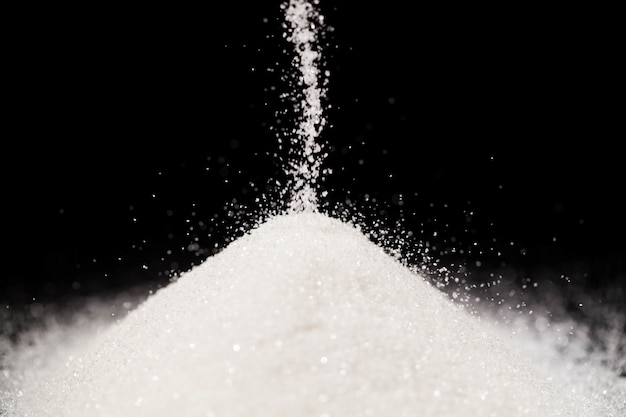 The sugar lies on the black background Free Photo