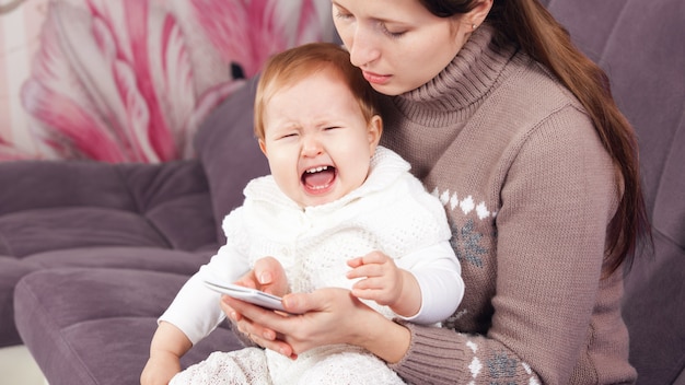 電話の女性は 泣いている子供を無視します 赤ちゃんが泣いています プレミアム写真