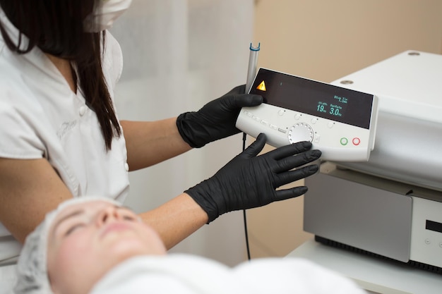 Premium Photo Therapist Beautician Makes A Laser Treatment To Young Womans Face At Beauty Spa