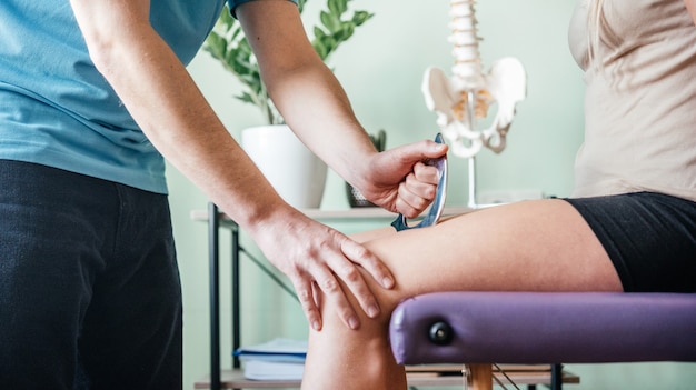 Premium Photo | Therapist using iastm instrument treatment, girl ...