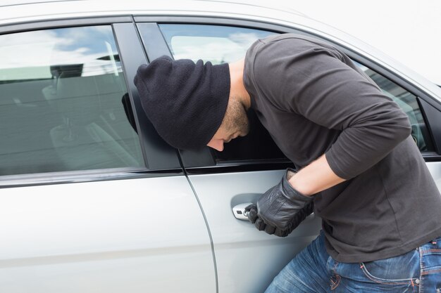 Premium Photo Thief Breaking Into A Car