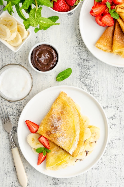 Premium Photo | Thin pancakes or crepes with chocolate cream and banana