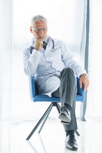 Free Photo | Thoughtful doctor sitting on chair