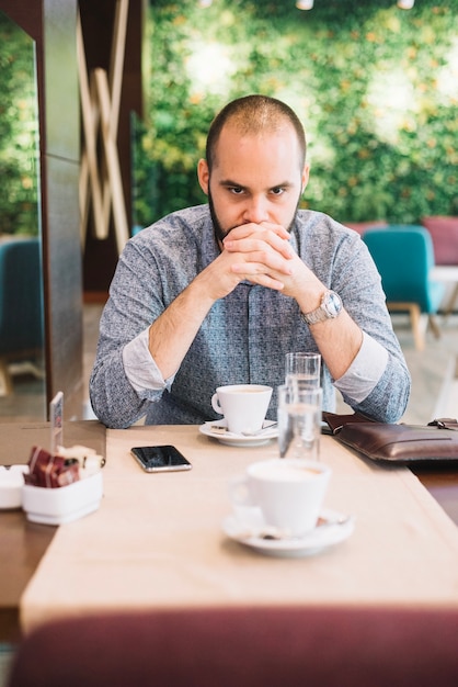 Thoughtful man having coffee in cafe | Free Photo
