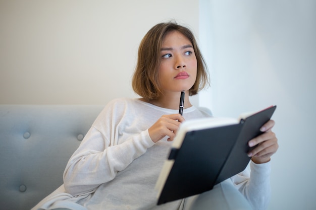 Free Photo | Thoughtful pretty asian woman studying at home