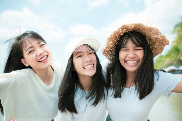 Three asian younger woman and teen happy on sea beach Premium Photo