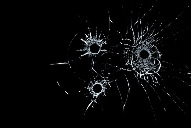 ガラスの3つの弾痕が黒い背景にクローズアップ プレミアム写真