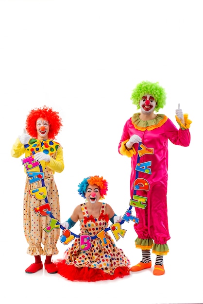 Premium Photo | Three funny playful clowns holding