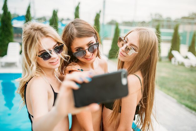 サングラスと水着姿の3人の女の子が自撮り プレミアム写真