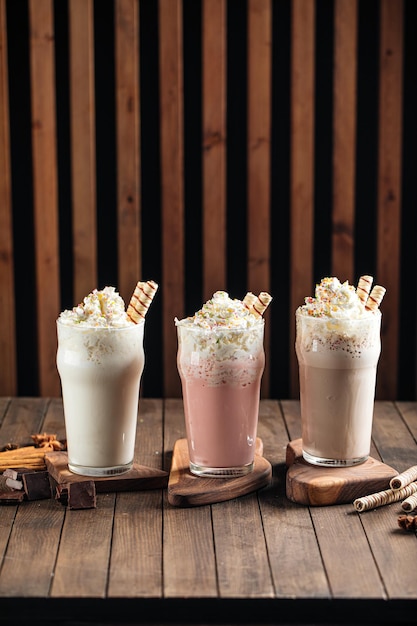 Premium Photo | Three glasses of sweet milkshakes with biscuits