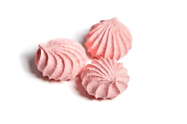3つのメレンゲクッキー ピンク色の白い背景で隔離のメレンゲのキス プレミアム写真