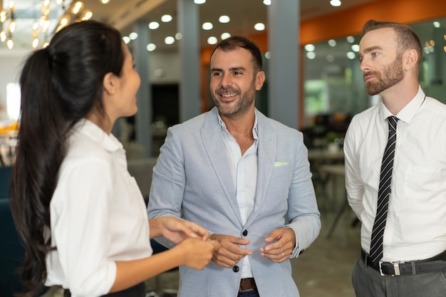 Free Photo | Three positive business people chatting in office lobby