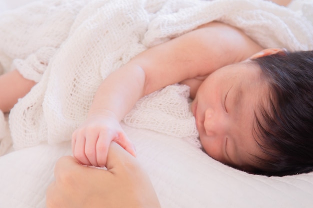生まれたばかりの赤ちゃんの小さな指が母親の手を握る プレミアム写真