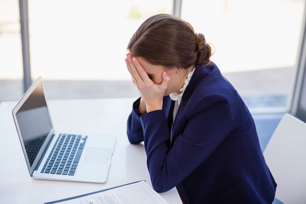 Premium Photo | Tired businesswoman sitting at desk with laptop