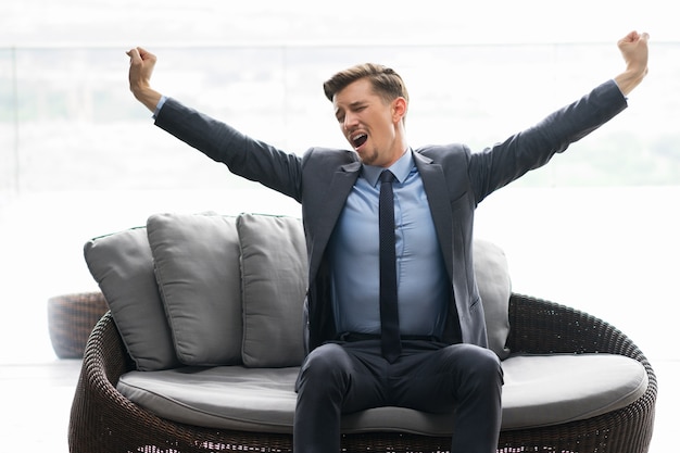 Tired Young Man Sitting On Couch And Yawning Free Photo