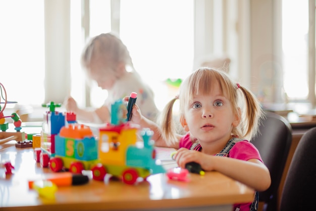 Toddler Girls Sitting At Desk Drawing Free Photo