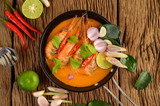 Tom yum kung thai hot spicy soup shrimp with lemon grass,lemon,galangal and chilli on wooden table, thailand food Free Photo