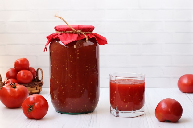 Premium Photo | Tomato juice in cans and in a glass is on the table