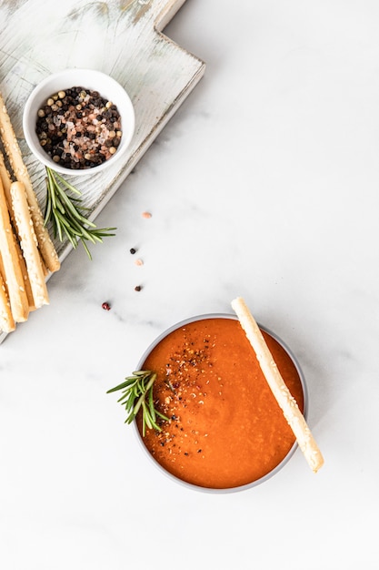 Premium Photo Tomato Soup Garnish With Ground Pepper Rosemary And Bread Sticks Light Background